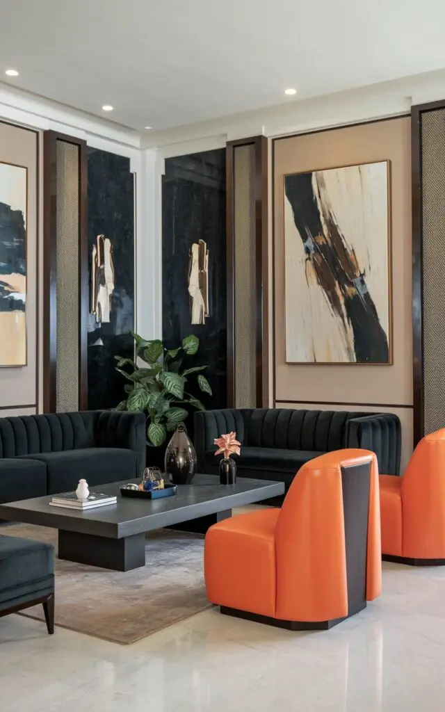 A photo of an art deco style modern luxurious living room. The room has a dark grey sofa and a dark grey coffee table. There are two bold accent chairs with a bright orange hue. The walls are adorned with abstract art pieces. The floor is made of white marble. There is a potted plant near the coffee table.