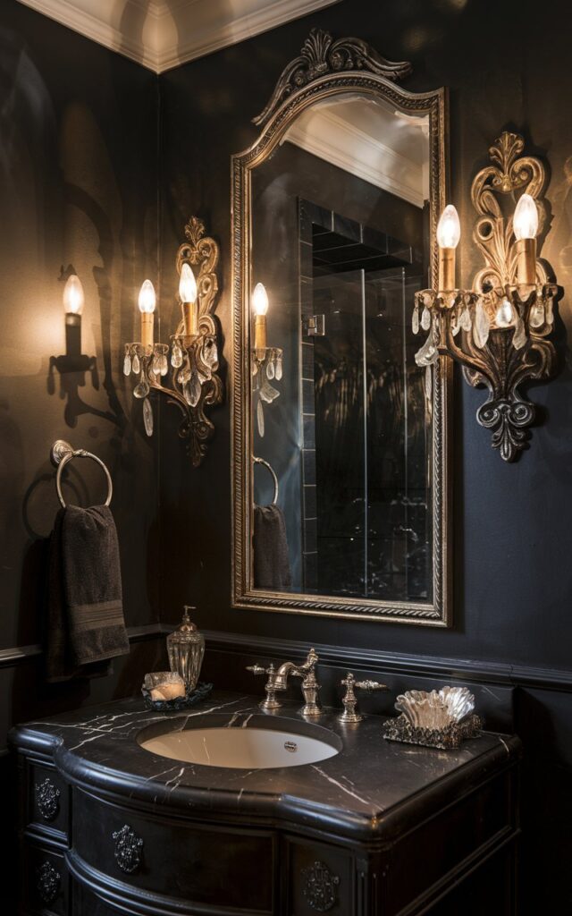 A photo of a vintage glam moody bathroom with a rich, velvety black wall paint. The bathroom is illuminated by ornate wrought-iron sconces flanking a gilded mirror. There is a marble-top vanity and crystal accents in the bathroom. The soft, golden light from the sconces casts dramatic shadows, enhancing the old-Hollywood-meets-Gothic-luxury vibe. The vanity and bathroom are fully furnished.