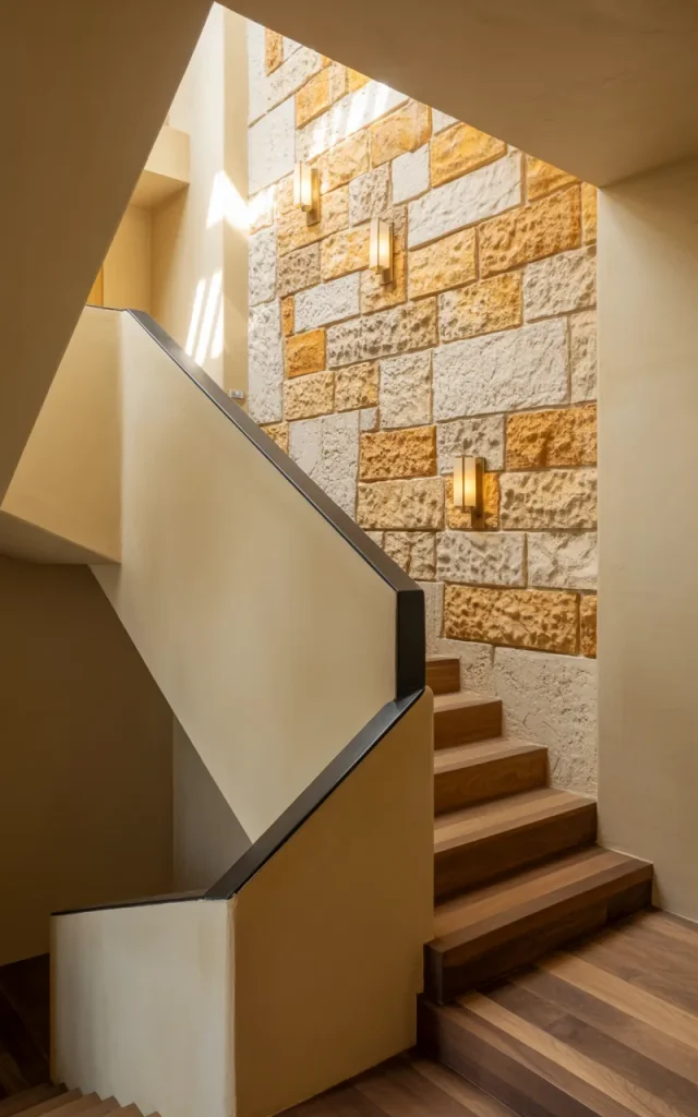 Highlight the staircase with textured stone walls