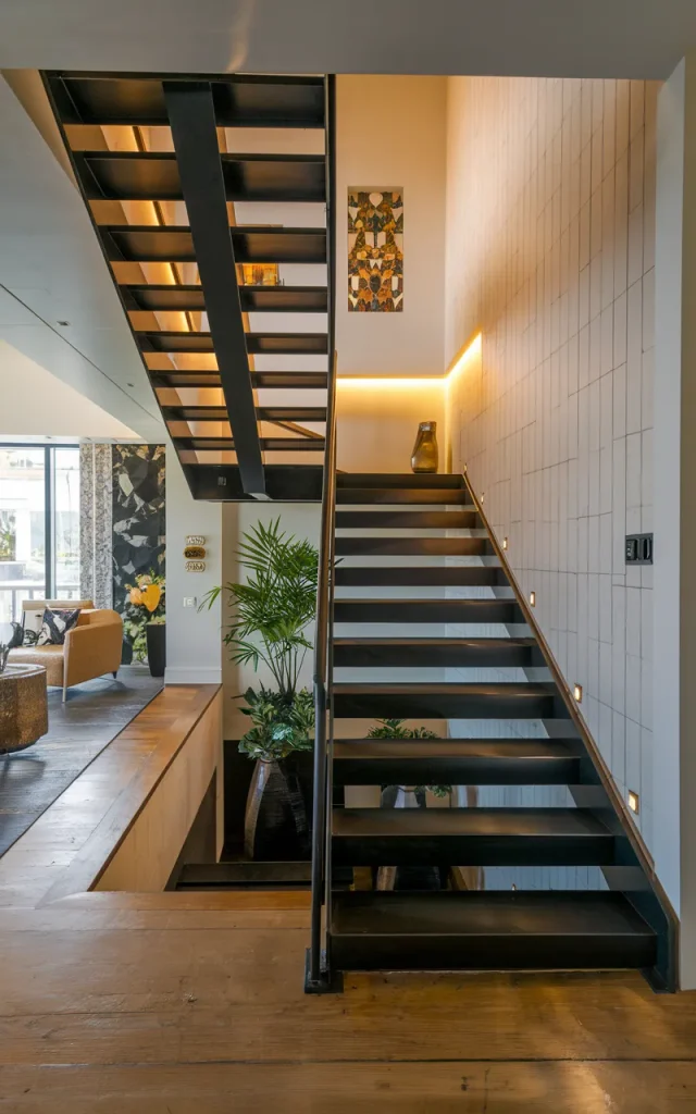 Use black steel stairs with warm spotlighting (Style match guide)